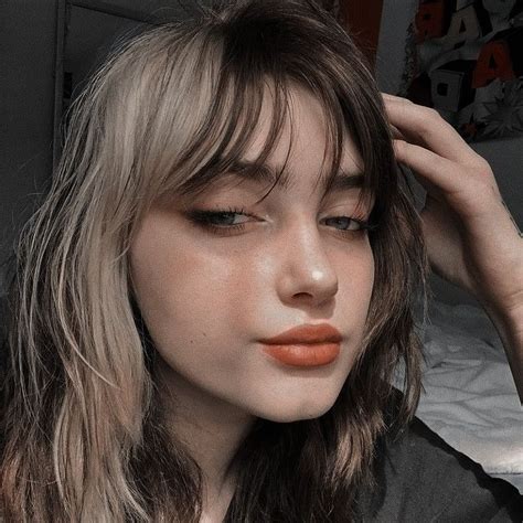 A Close Up Of A Person With Long Hair And An Orange Lipstick On Their Lips