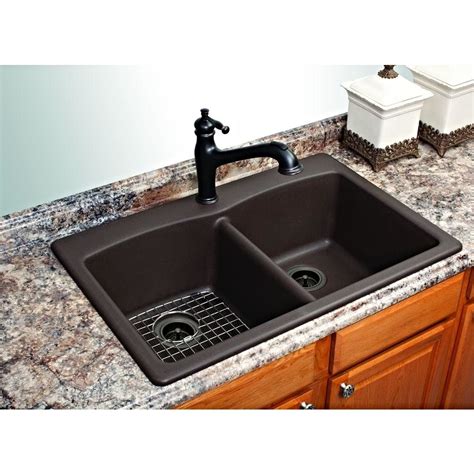 A Kitchen Sink With Two Black Faucets On Top Of It And Granite Counter Tops