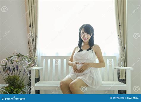 Young Pregnant Asian Woman Holds Her Hands On Her Swollen Belly Love