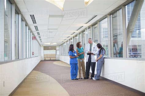 Doctor And Nurses Talking In Hospital Hallway Stock Photo Dissolve