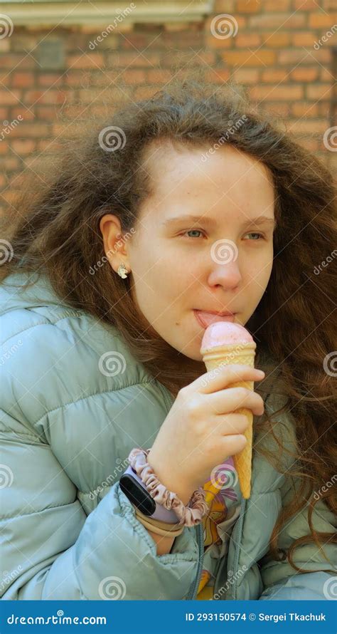 Teenager Girl Licks Scoop Of Ice Cream In Waffle Cone Hesitantly And
