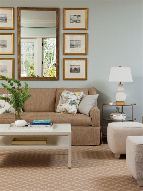 In this living room, a navy wall and sofa help to set off the pinks in the cushions, rug and artwork. Light Blue Living Room is Airy, Cozy | HGTV