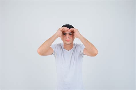 Free Photo Young Male In T Shirt Looking Far Away With Hand Over Head