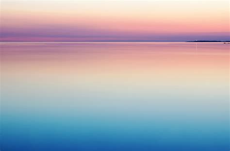 A Peaceful And Serene Pastel Pink And Purple Sunset Reflecting On Still