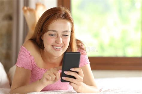 Happy Woman Using Smart Phone Lying On The Bed At Home Stock Image Image Of Laughing Bedroom