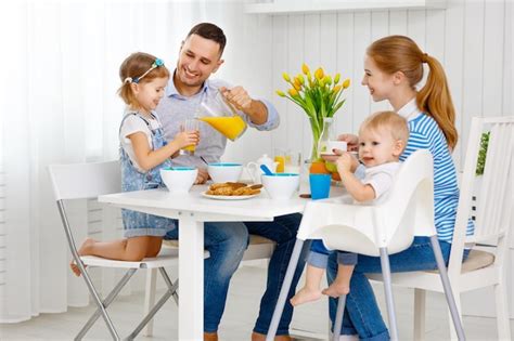 Familia Feliz Madre Padre E Hijos En El Desayuno Foto Premium