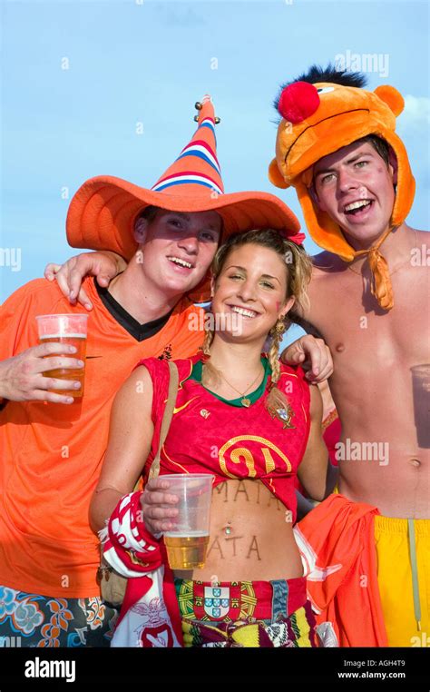 Portrait Of Two Male Holland Fans Sandwiching A Female Portugal Fan Before Their Match During
