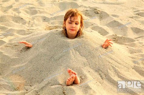 Little Girl After Swimming Is Buried In Sand On Beach A Lot Of Yellow