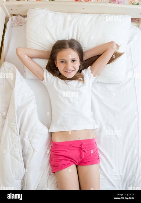 View From Above On Cute Brunette Girl Lying On Bed And Looking At Camera Stock Photo Alamy