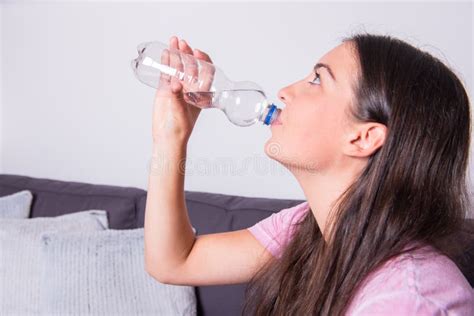 Portrait Of A Young Beautiful Woman Drinking Water Out Of The Bo Stock
