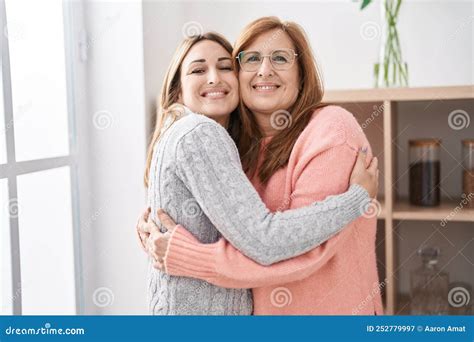Mother And Daughter Hugging Each Other Standing At Home Stock Image