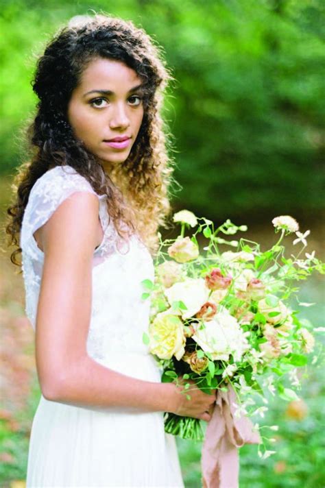 A Beautiful Young Woman Holding A Bouquet Of Flowers