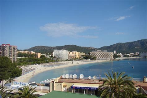 The Beach Is Lined With Palm Trees And Buildings On Both Sides Along