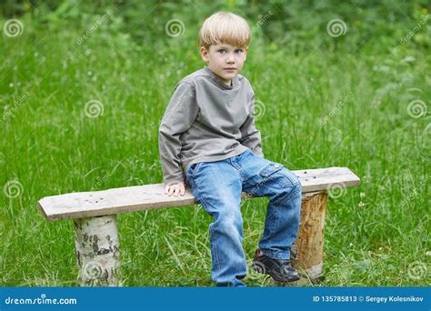 Little Blond Smiling Boy Sitting On A Park Bench Stock Image Image Of