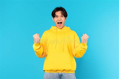Enthousiaste Japanse Tiener Schreeuwt Ja Tegen Blauwe Achtergrond Stock