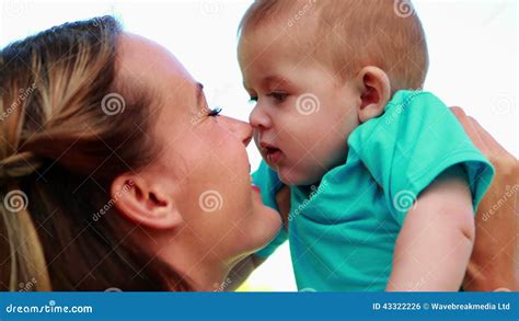 Happy Mother Rubbing Noses With Cute Baby Son In The Park Stock Footage