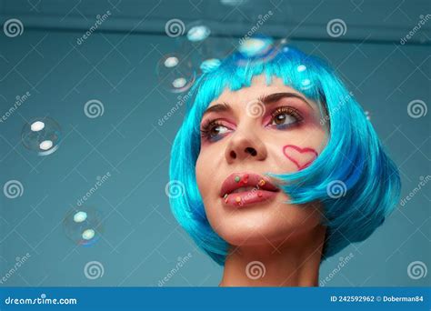 Beautiful Young Woman With Blue Wig And Bright Make Up In Soap Bubbles