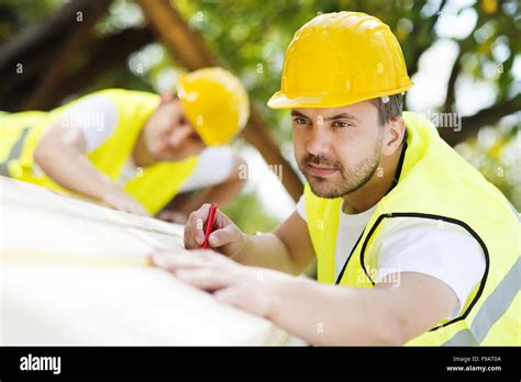 Construction Workers Collaborating On New House Building Stock Photo