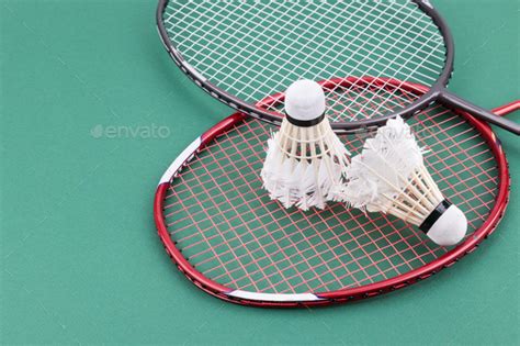 Download Two worned out badminton shuttlecock with racket on green ...