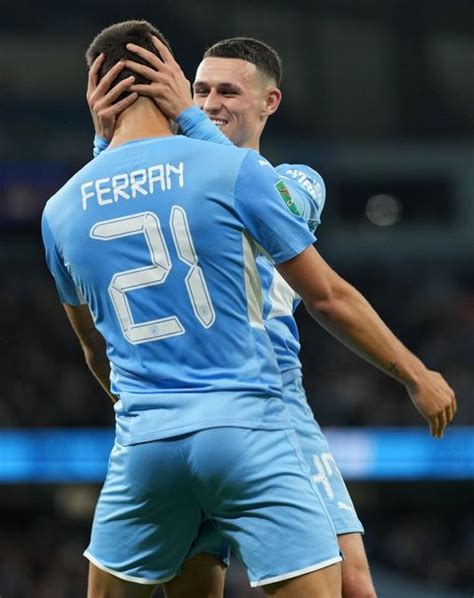 Two Soccer Players Hugging Each Other On The Field