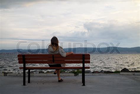 A Woman Sitting On A Bench In The Early Stock Image Colourbox