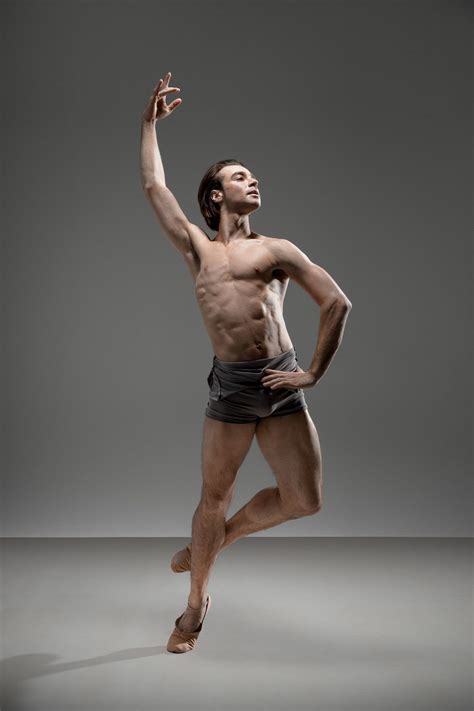 A Man In Black Shorts And No Shirt Is Dancing With His Hands Up To The Side