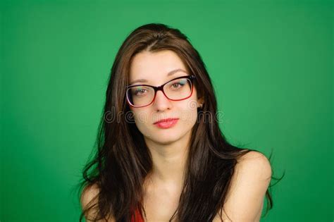 Studio Portrait Of Cute Smart Girl In Eyeglasses And Red Top On Green
