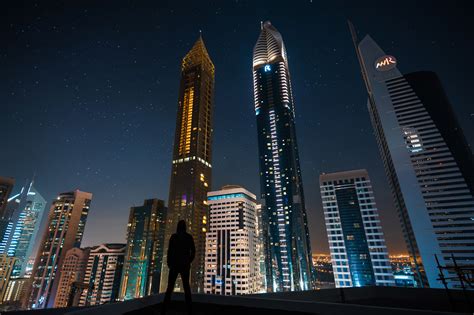 1920x1080 Man Standing Front Of Tall Buildings Laptop Full Hd 1080p Hd