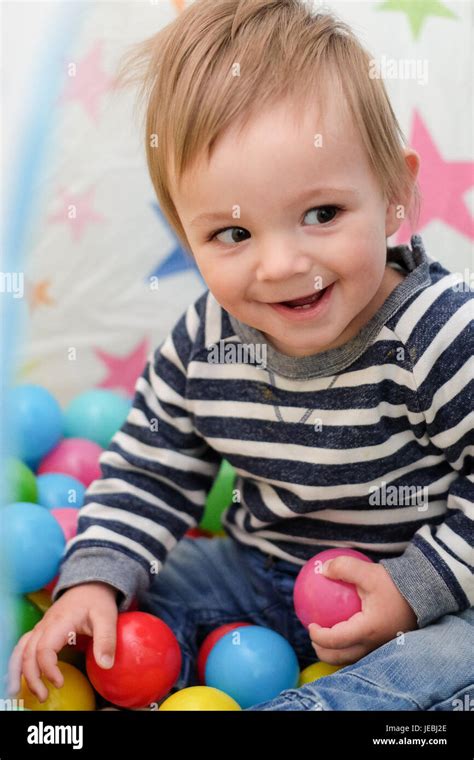 Baby Boy Playing With Coloured Balls Stock Photo Alamy