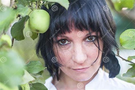Portrait Of A Young Dark Haired Woman Under The Apple Tree In The