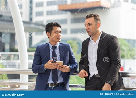 Two Young Businessmen Standing And Talk About Work Stock Photo Image