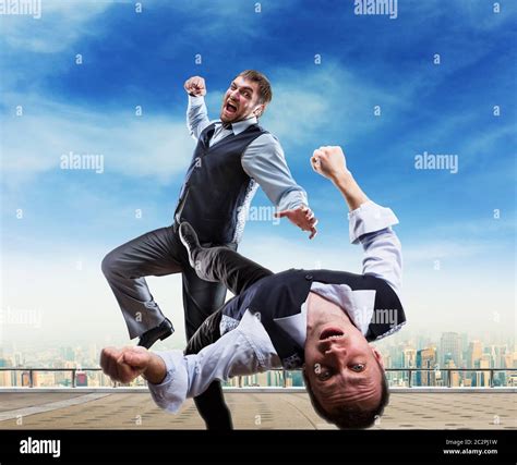 Two Businessmen Fighting On The Roof Stock Photo Alamy