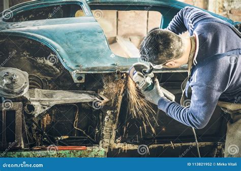Young Man Mechanical Worker Repairing Old Vintage Car Body With Stock