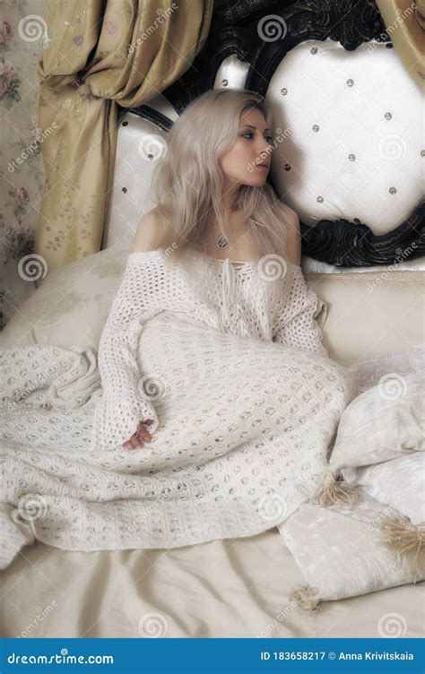 Beautiful Blonde With A White Knitted Sweater Sitting On The Bed Stock Image Image Of Cozy