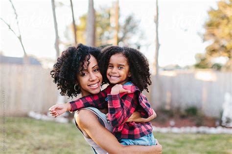 a mother and daughter with curly hair enjoying a beautiful day outdoors by kristen curette