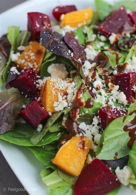 A Salad With Beets Carrots And Feta Cheese On It Is Sitting On A White Plate