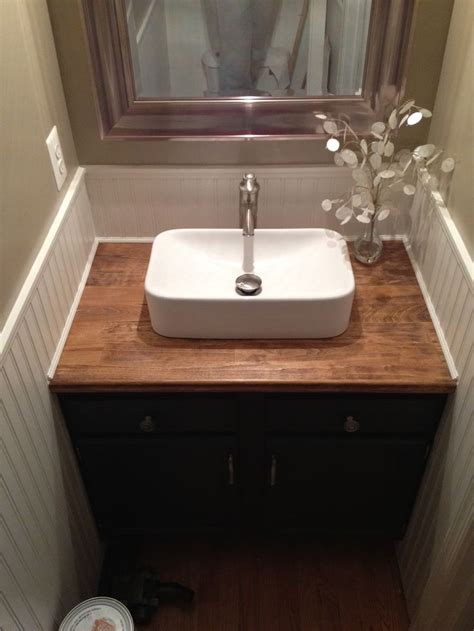 A Bathroom Sink Sitting Under A Window Next To A Wooden Counter With A