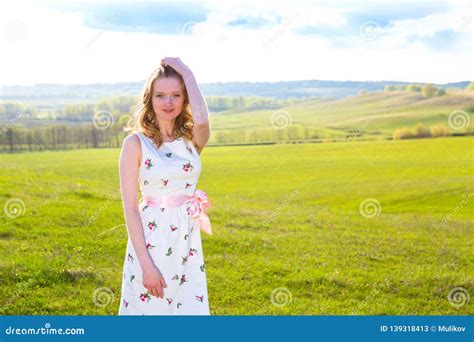 Cute Young Blonde Woman In Green Field At Summer Or Spring Sunset Stock