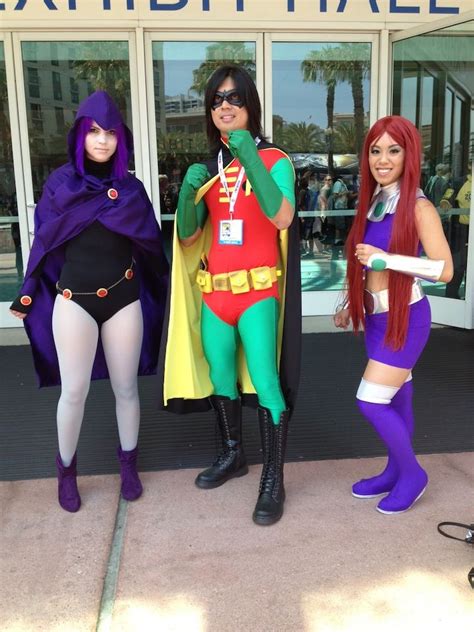 three women dressed up as superheros standing in front of a building
