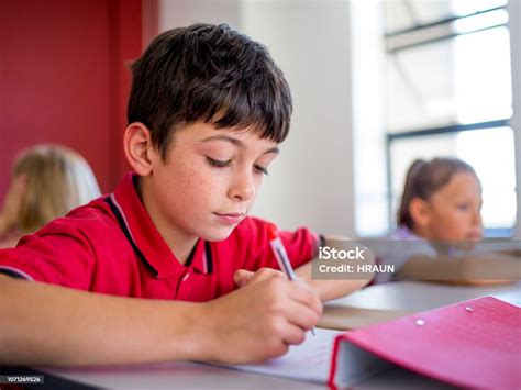 Niño Escribiendo En Papel Durante El Examen En Aula Foto De Stock Y Más