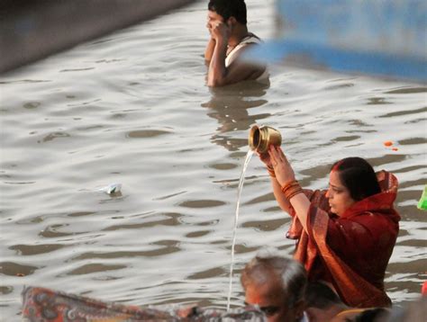 A Woman Devotee Performs Rituals While Offering Prayers In River Ganga During Chhath Puja