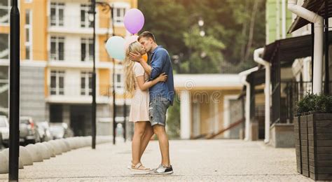 Passionate Young Couple Kissing In Street Holding