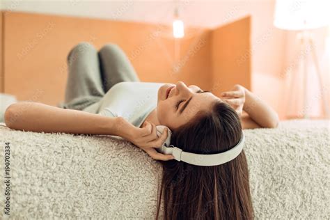 Favorite Music Beautiful Teenage Girl Lying On Her Bed And Listening