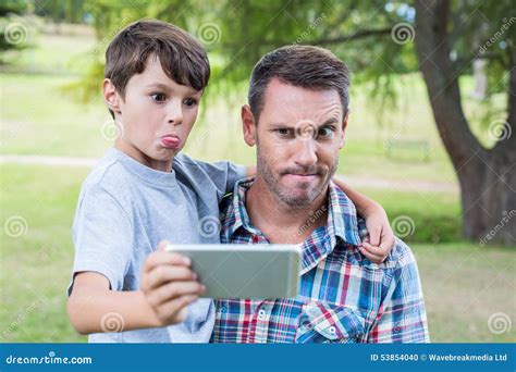 Padre E Hijo Que Toman Un Selfie En El Parque Foto De Archivo Imagen