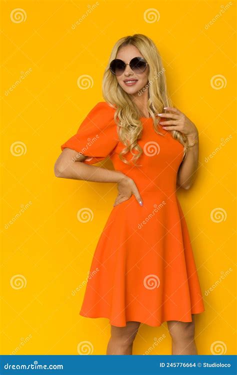 schöne blonde frau posiert in orangefarbenem cocktailkleid und sonnenbrille stockfoto bild von