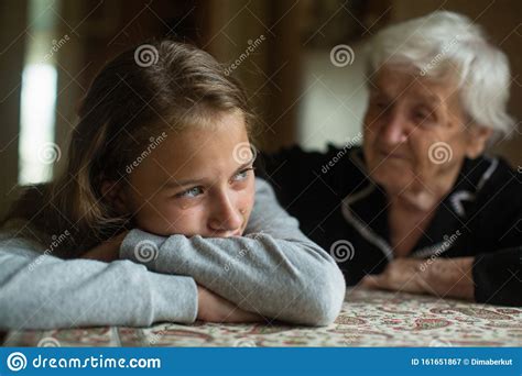 Vieja Abuelita Consolando A Una Nieta Llorosa Imagen De Archivo