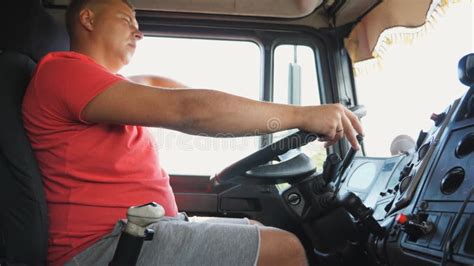Male Hands Of Lorry Driver Holds A Big Steering Wheel While Driving A