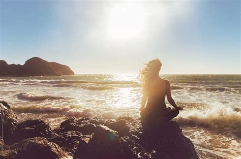 Pretty Woman Meditating By The Ocean Del Colaborador De Stocksy