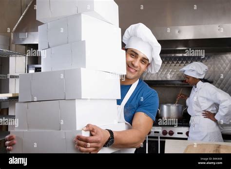Hispanic Male Pastry Chef Carrying Stack Of Boxes Stock Photo Alamy