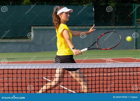 professional equipped female tennis player beating hard the tennis ball with racquet stock